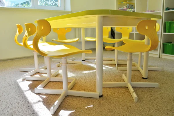 Barnstolar och bord för dagis eller grundskola, gult i soligt rum — Stockfoto