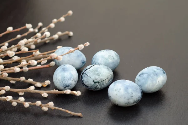 Altı mavi mermer yumurta, ambar çayına boyanmış, söğüt dalları siyah bir arka planda yatıyor.