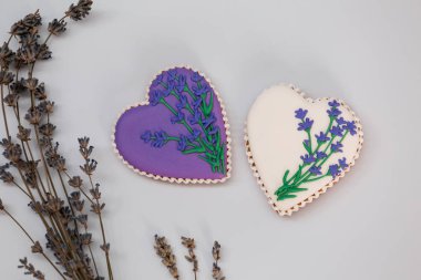 Eflatun çiçeklerle süslenmiş mor ve beyaz kalpler şeklinde zencefilli kurabiyeler..