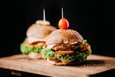 Sığır eti kesmek için kullanılan iki ağız sulandıran lezzetli ev yapımı hamburger. ahşap masanın üstünde. Eklenen bıçak hamburgerler.
