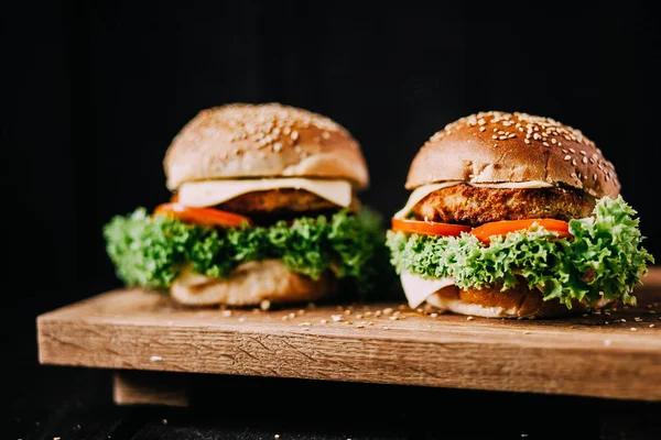 Sığır eti kesmek için kullanılan iki ağız sulandıran lezzetli ev yapımı hamburger. ahşap masanın üstünde. Eklenen bıçak hamburgerler.