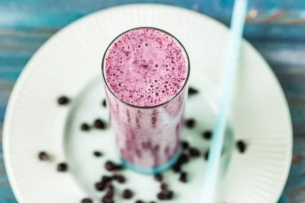 Taze sulu blueberry smoothie chia tohum ile cam ve çiçekler ile taze çilek. Yaz içeceği. Üstten Görünüm