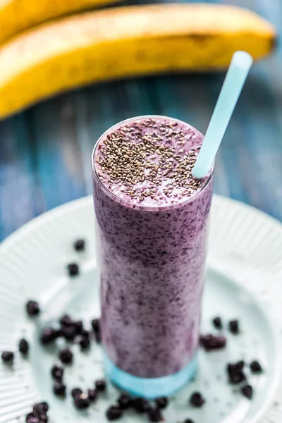 Taze sulu blueberry smoothie chia tohum ile cam ve çiçekler ile taze çilek. Yaz içeceği. Üstten Görünüm