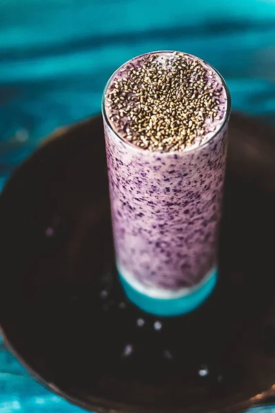 Taze sulu blueberry smoothie chia tohum ile cam ve çiçekler ile taze çilek. Yaz içeceği. Üstten Görünüm