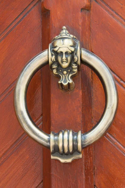 old bronze door handle on brown wooden urban door