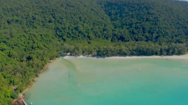 Turkuaz deniz, beyaz sahil ve orman dağlarında yelkenli teknesi olan ahşap iskele, Asya 'da açık gökyüzünde her gün tepedeki drone' un görüş açısıyla yer alıyor..