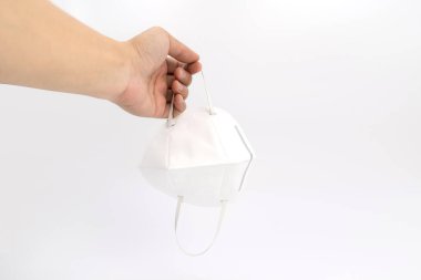 Asyalı erkek eli, beyaz arka planda 2.5 numaralı stüdyo ışığıyla bembeyaz bir maske tutuyor..