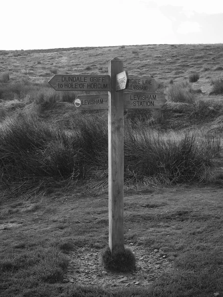 Signpost on walking paths shot in black and white — Stock Photo, Image