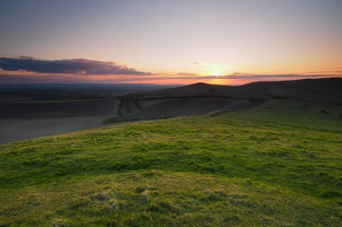 Knap Hill 'in tepesinden gün batımı Pewsey Vadisi, Kuzey Wessex Downs, Wiltshire' a bakıyor.