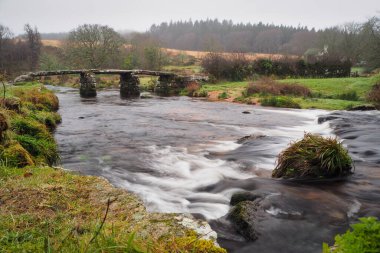 13. yüzyıldan kalma, Dartmoor Ulusal Parkı, Devon, İngiltere 'de, Postbridge' deki Doğu Dart Nehri üzerine inşa edilmiş taş bir köprü.