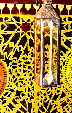 Oryantal desenli arka plan önünde asılı gümüş fener