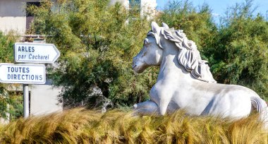 Camargue 'nin beyaz atı - Akdeniz' deki Petit Rhne ağzının doğusunda yer alan Fransız Bouches-du-Rhne departmanındaki Camargue 'de küçük bir kasaba ve hac alanı olan Saintes-Maries-de-la-Mer' in ana meydanındaki heykel..