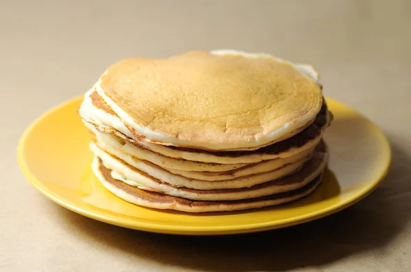 Empilement de crêpes sur une assiette jaune — Photo