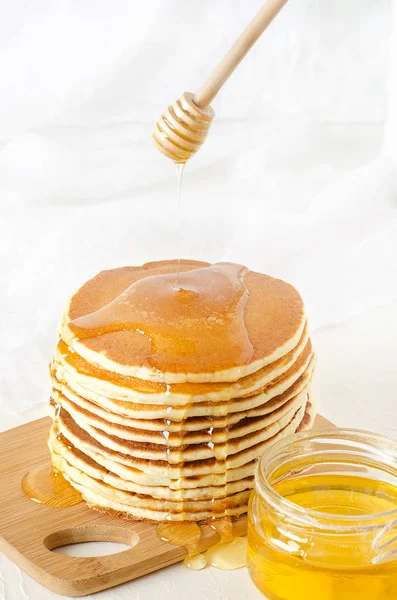 Pila de panqueques en un plato amarillo con miel — Foto de Stock