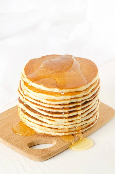 Pila de panqueques en un plato amarillo con miel — Foto de Stock