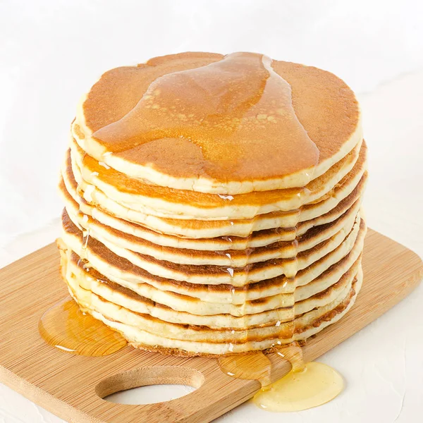 Stapel Pfannkuchen auf einem gelben Teller mit Honig — Stockfoto