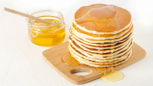 Pila de panqueques en un plato amarillo con miel — Foto de Stock