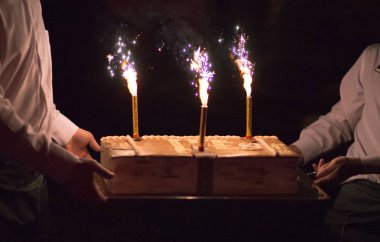 Garsonlar bir doğum günü pastası taşımak