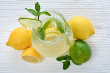 Narenciye limonata ve kireç limon dilimli, sağlıklı su ve su içmek Beyaz ahşap masa üzerinde yaz aylarında Detoks