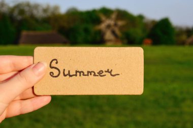 Yaz metin bir kart. Kız holding kartı windmi bir alana