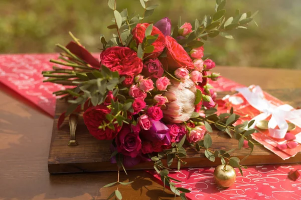 Buquê de casamento vermelho com decoração de casamento em uma mesa — Fotografia de Stock