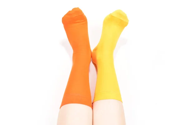 Gelbe und orangefarbene Socken am Frauenfuß isoliert auf weißem Hintergrund — Stockfoto