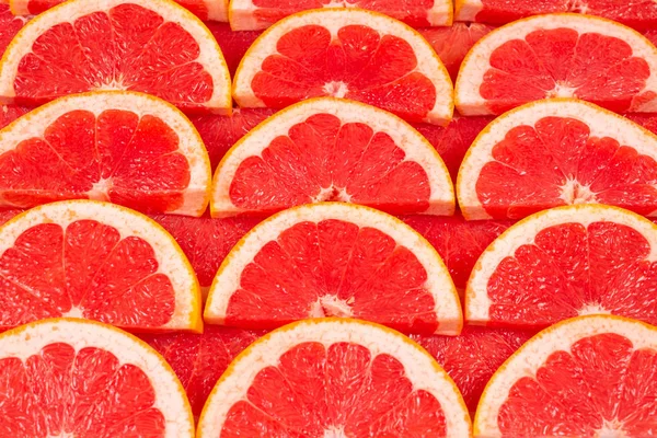 Grapefruitrot saftige Scheiben Hintergrund. Ansicht von oben. — Stockfoto