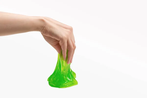 Zielony szlam zabawka w kobieta ręka odizolowany na biały. — Zdjęcie stockowe