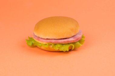 Jambonlu sandviç, peynir, turuncu arka planda marul..