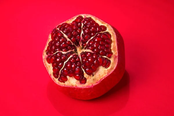 Sladké granátové jablko na červeném pozadí. — Stock fotografie