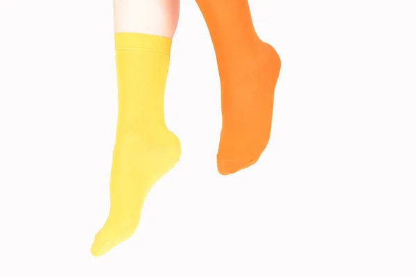 Жовті та помаранчеві шкарпетки на жіночій нозі ізольовані на білому фоні — стокове фото