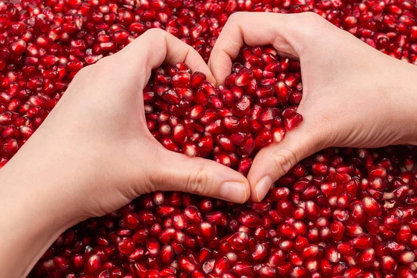 Kalp sembolü. Kadınların elinde nar tohumları.