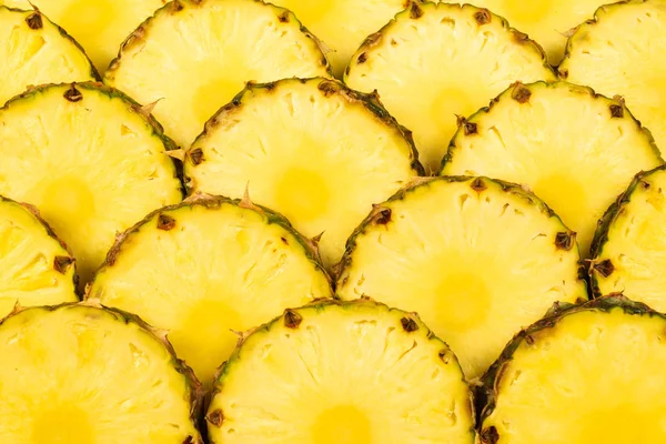 Ananas sappige gele plakjes achtergrond. Bovenaanzicht. — Stockfoto
