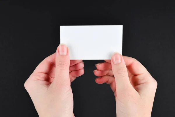 Prázdná karta v ruce ženy na černém pozadí. — Stock fotografie