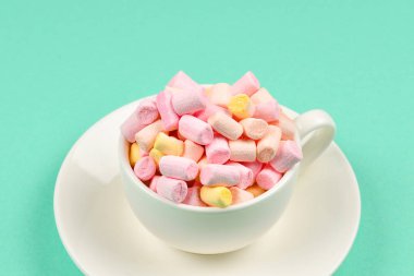 Yeşil arka planda marşmelov bardağı. Boşluğu kopyala.