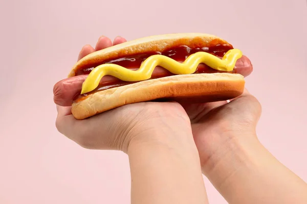 Hot Dog in der Hand der Frau isoliert auf weißem Hintergrund. Kopierraum. — Stockfoto