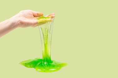 Yeşil sümüklü oyuncak beyaz ellerle izole edilmiş kadında.