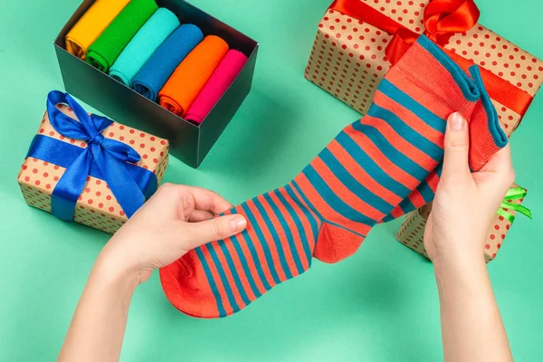 Színes gyűjtemény pamut zokni, mint egy ajándék a női kézben. — Stock Fotó
