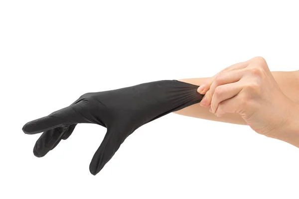 Žena si nasadí černé gumové rukavice. — Stock fotografie