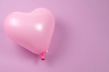 Mor arkaplanda pembe balon.