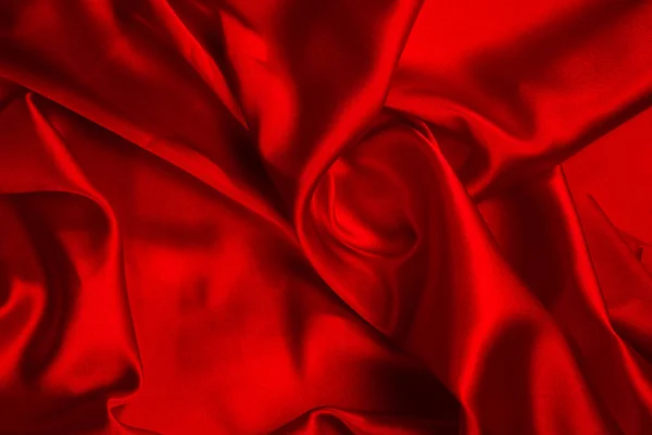 Красный шелк или атласная роскошная текстура ткани может использоваться в качестве абстрактной спины — стоковое фото