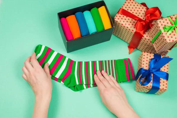 Színes gyűjtemény pamut zokni, mint egy ajándék a női kézben. — Stock Fotó