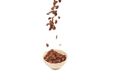 Çukulatalı mısır gevrekleri Whit 'e izole edilmiş beyaz kaseye düşüyor.