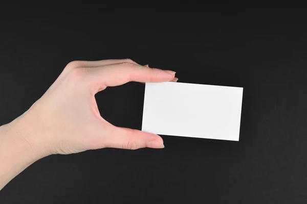 Prázdná karta v ruce ženy na černém pozadí. — Stock fotografie