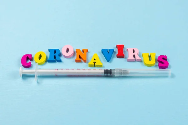 Woord Coronavirus geschreven op blauwe achtergrond. Bovenaanzicht. — Stockfoto