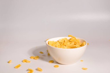 Mısır gevrekleri beyaz kaseye düşüyor. Hareket. 