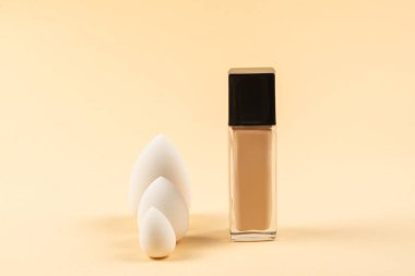 Bej arka planda küçük, orta ve büyük beyaz güzellik karıştırıcısı ve makyaj vakfı. Üst görünüm. 