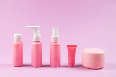 Pembe plastik şişeler hijyen ürünleri, kozmetik ürünleri, pembe arka planda hijyen ürünleri. Boşluğu kopyala. 