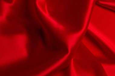 Kırmızı ipek ya da saten lüks kumaş dokusu soyut bir arka plan olarak kullanılabilir. Üst görünüm.