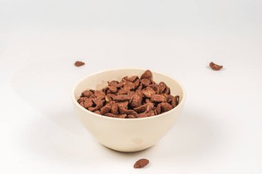 Beyaz kaseye düşen çikolatalı mısır gevreği. Hareket. Kopyalama alanı.